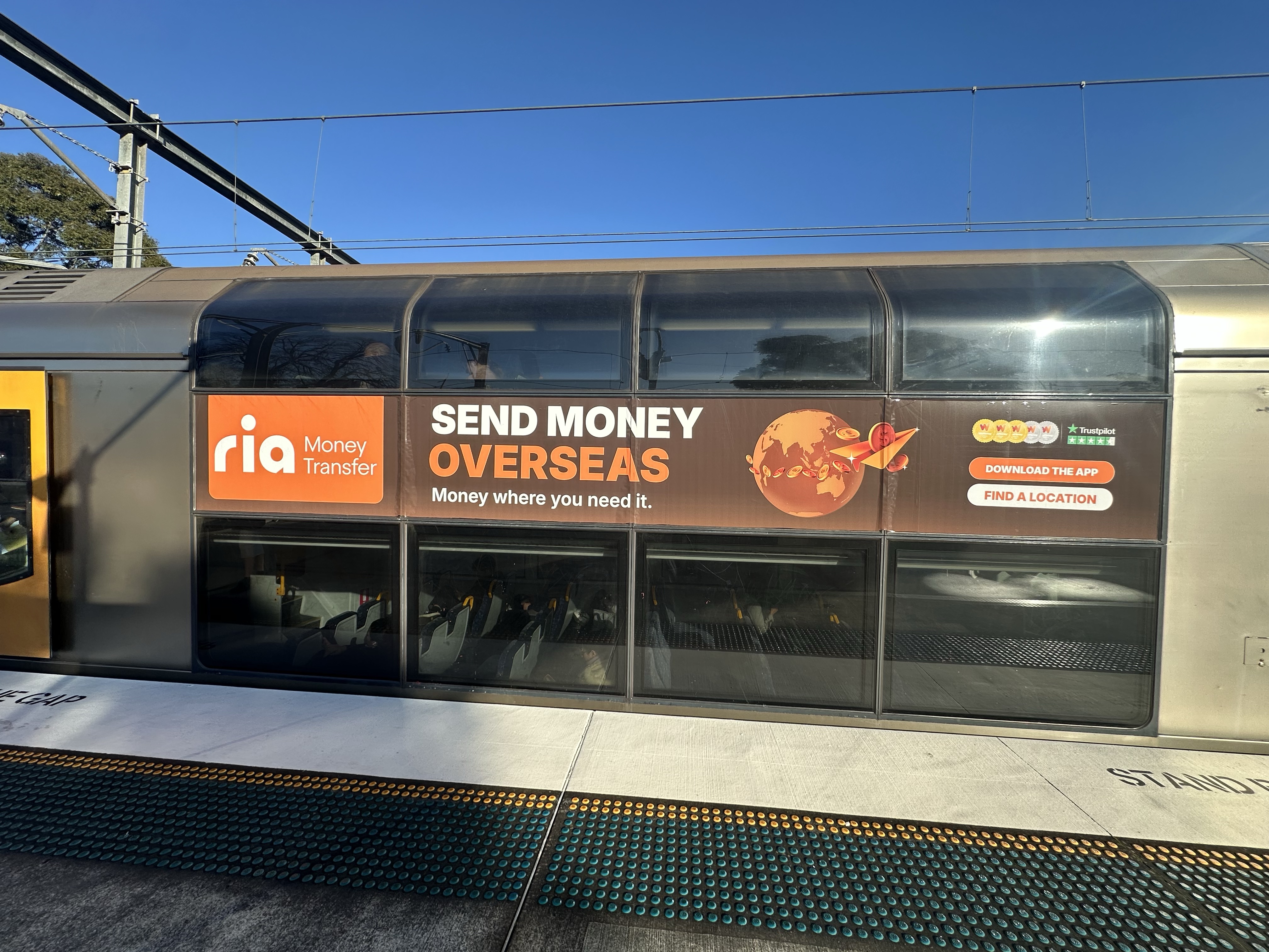 RIA Money Transfer brand awareness ad on a Sydney train carriage